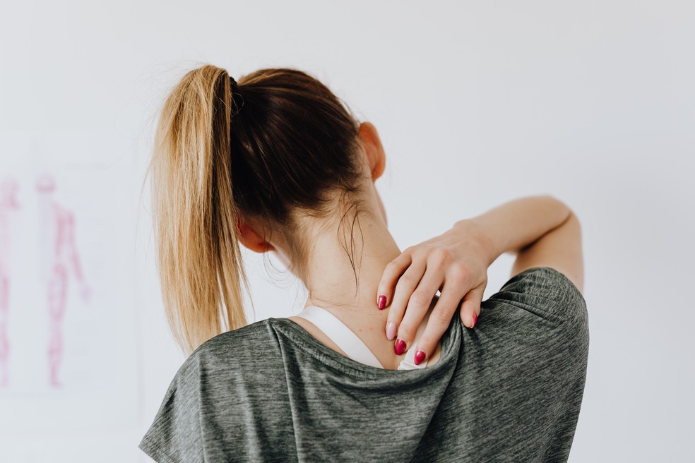 Ficar muitas horas sentado com a coluna curvada em frente ao notebook pode causar dores na coluna — Foto: Pexels/Karolina Grabowska